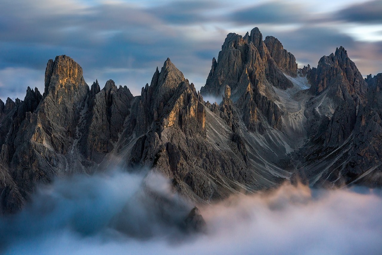 Sharp Dolomite peaks stand above low cloud in the last light of day.