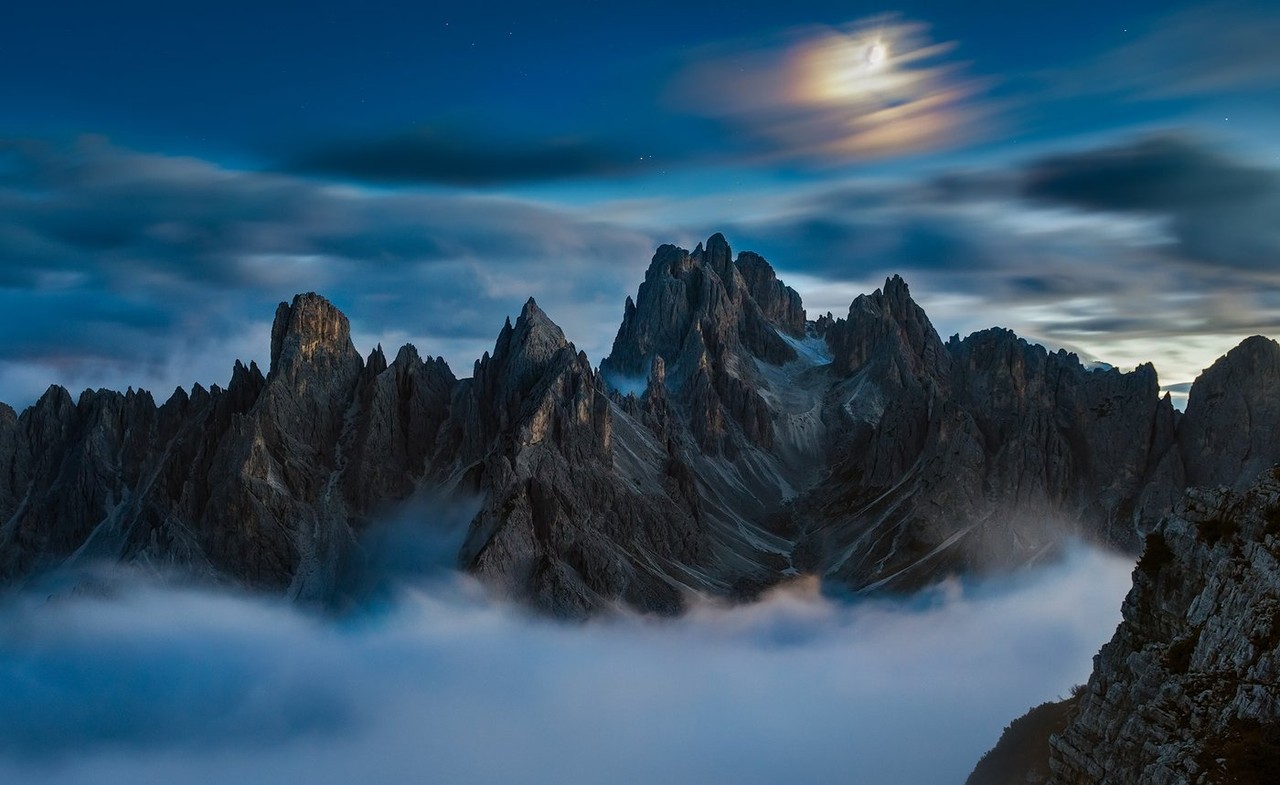 Snow-dusted Dolomite peaks recede into blue mountain haze.
